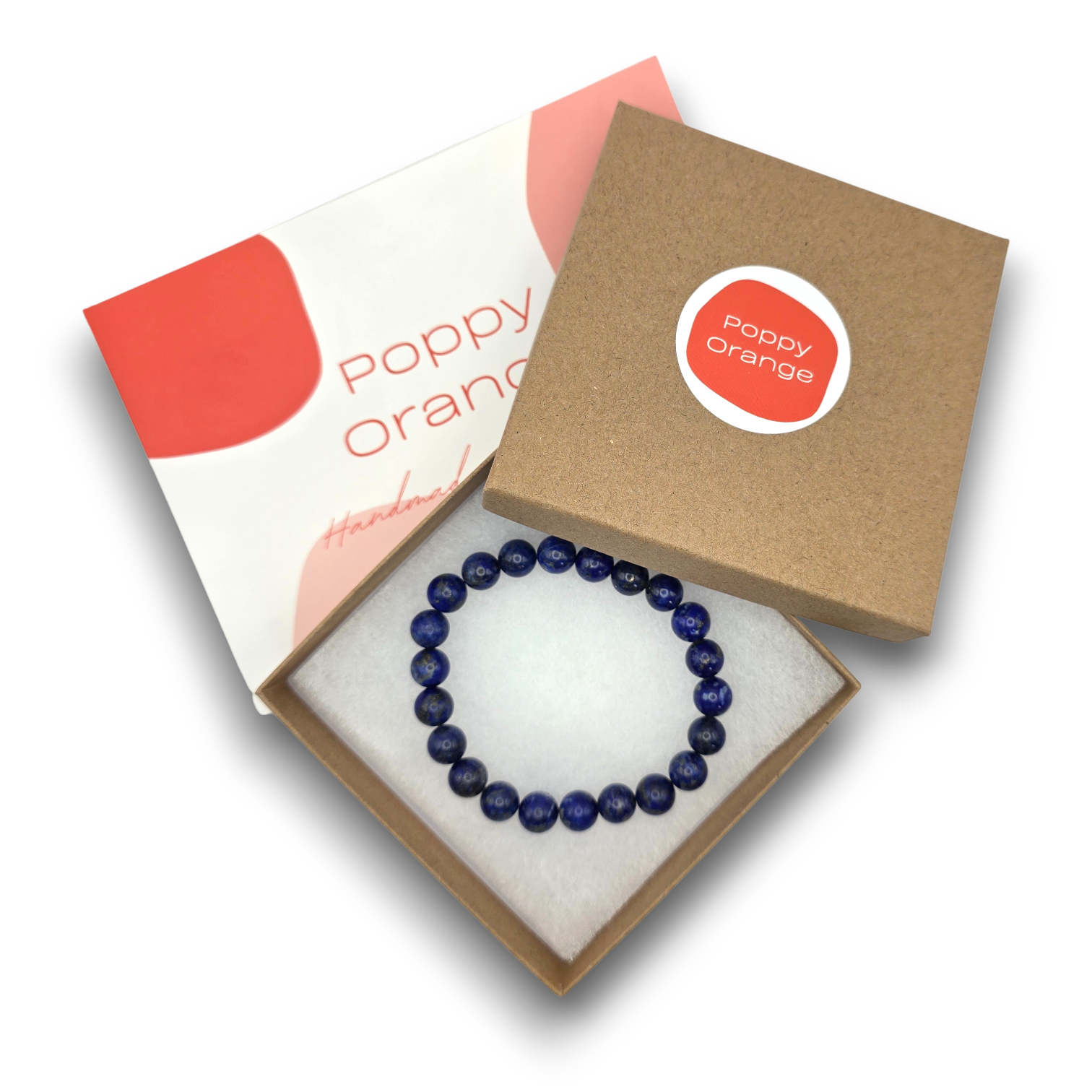 A beaded bracelet made of dark blue lapis lazuli stones, presented inside an open kraft gift box with a white foam insert. The box lid is shown next to it, displaying the brand logo 'Poppy Orange' and the text 'Poppy orange Handmade'.