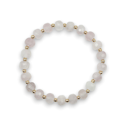 A beaded stretch bracelet featuring faceted pale pink Rose Quartz beads separated by small gold spacer beads, displayed on a clean white background.