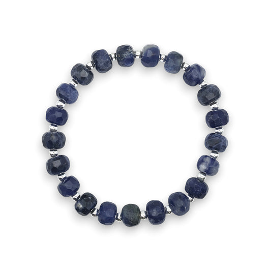A beaded stretch bracelet made of blue Sodalite faceted beads separated by small silver spacer beads, shown on a plain white background.