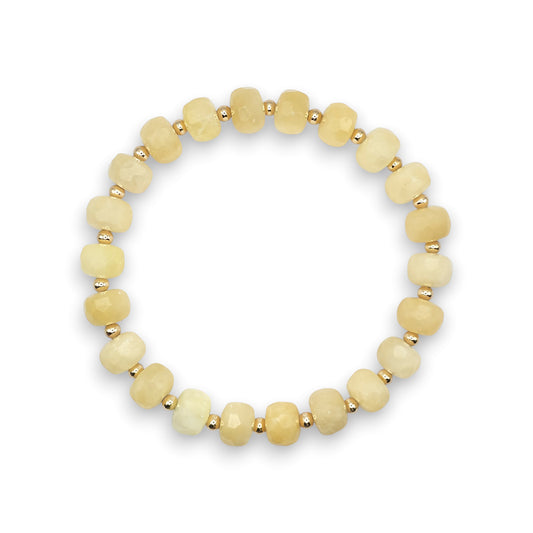 A stretch bracelet made of faceted Yellow Calcite beads separated by small gold spacer beads, shown on a plain white background.