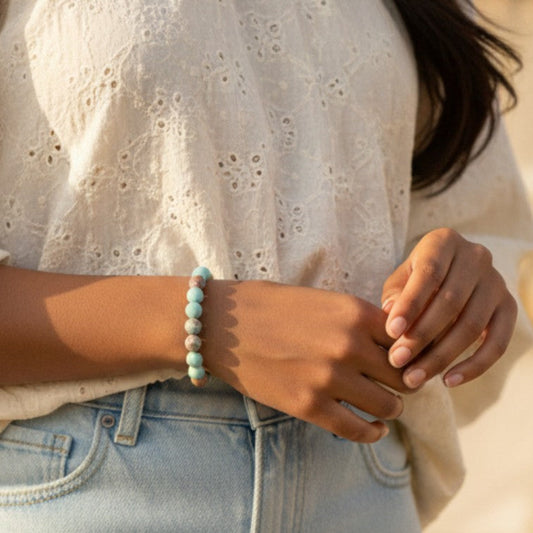Person wearing a light-colored blouse and blue jeans with a blurred background